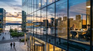 A high-quality, professional editorial photograph of a modern Norwegian cityscape reflected in a sle