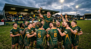 A professional editorial photograph of a local grassroots sports team celebrating on a pitch, captur